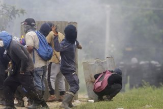 Des manifestants qui protestent contre la nouvelle loi sur la sécurité sociale, font face aux forces de l'ordre. KEYSTONE/EPA/CARLOS LEMOS